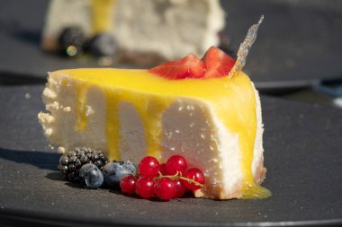 Lezzetli bir dutlu cheesecake 'in yakın plan fotoğrafı. Bir sokak kafeteryasındaki masada.