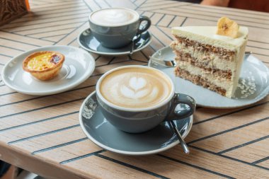 Coffee cups and sweets on the cafe table. Delicious coffee break