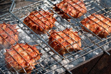 Delicious juicy meat been cooked on a barbecue in the garden