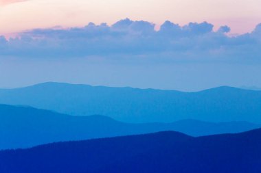 Puslu dağ siluetleri. Dağlarda manzaralı bir akşam. Tonsal perspektif