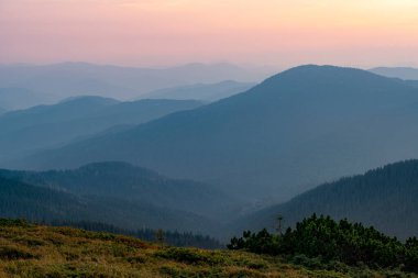 Dağlarda güzel, sakin bir akşam. Pembe dağ siluetleriyle gün batımı