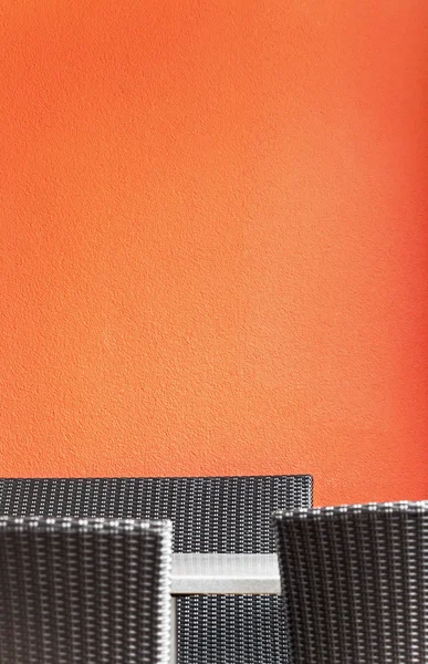 Sedie in rattan nero di fronte al muro rosso — Foto Stock