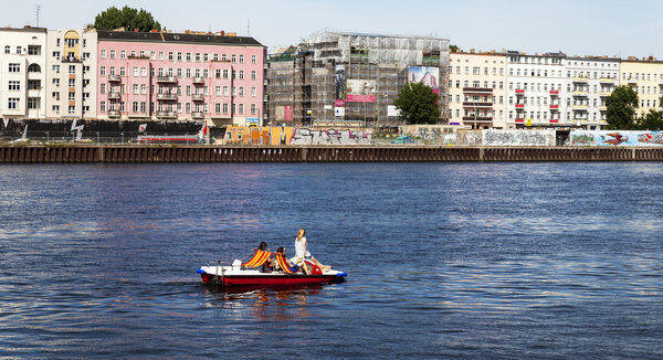 Young women drive pedal boat on the Spree River in Berlin Mitte