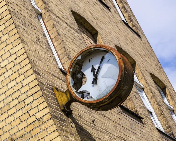 Broken clock on the facade of a factory building