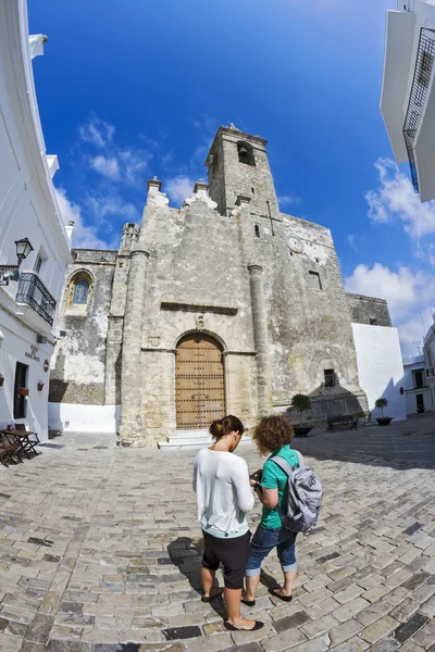 Dos turistas femeninas se encuentran frente a la Iglesia de Santa María en el pueblo andaluz de Vejer de la Frontera — Foto de Stock