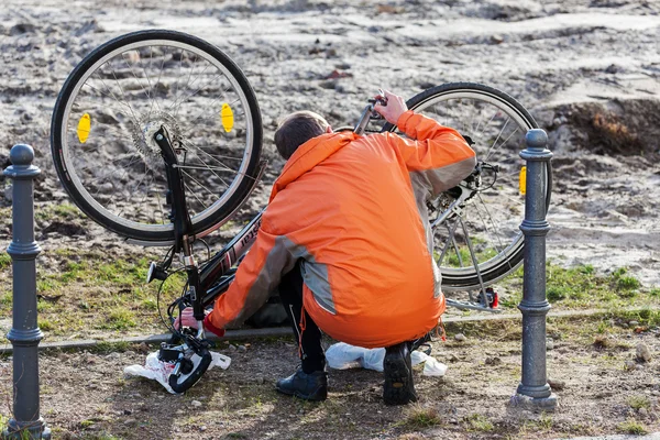 Um homem tem um contratempo nos pneus da bicicleta. — Fotografia de Stock