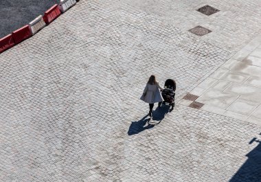 bebek arabası gri asfalt üzerinde olan kadın
