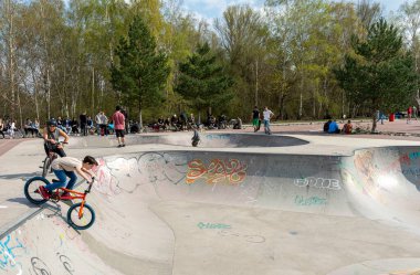 Skateboard and cyclists in a skate pool in the amusement park at Gleisdreieck Park in Berlin-Mitte, Germany