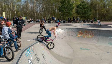 Skateboard and cyclists in a skate pool in the amusement park at Gleisdreieck Park in Berlin-Mitte, Germany