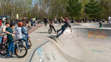 Skateboard and cyclists in a skate pool in the amusement park at Gleisdreieck Park in Berlin-Mitte, Germany