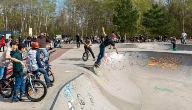Skateboard and cyclists in a skate pool in the amusement park at Gleisdreieck Park in Berlin-Mitte, Germany