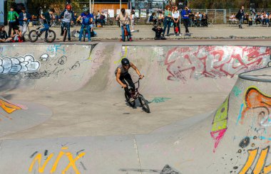 Skateboard and cyclists in a skate pool in the amusement park at Gleisdreieck Park in Berlin-Mitte, Germany