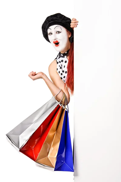 Pretty mime woman holding blank billboard and shopping bags — Stock Photo, Image