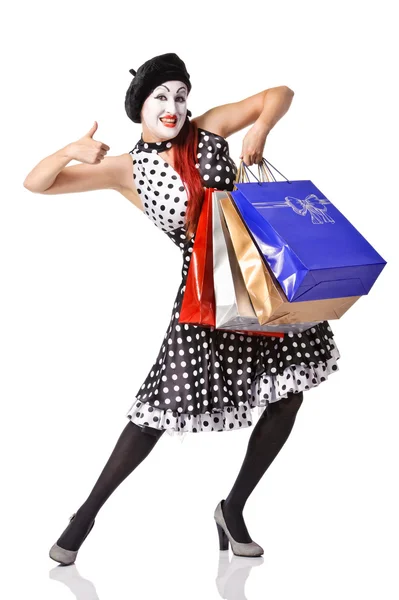 Grappige mime in vlekkerige jurk bedrijf shopping tassen — Stockfoto