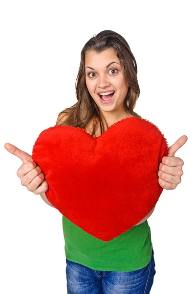 Ευτυχισμένη νέα γυναίκα που κρατά κόκκινο σε σχήμα καρδιάς μαξιλάρι — Φωτογραφία Αρχείου