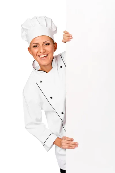 Chef, panadero o cocinero sonriendo feliz sosteniendo en blanco signo de papel blanco — Foto de Stock