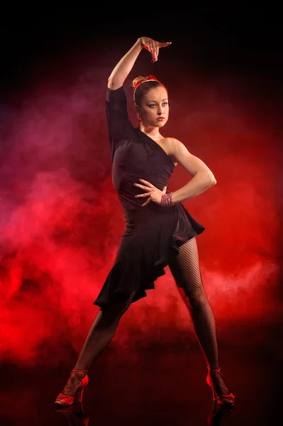 Jeune femme dansant le flamenco sur fond rouge foncé — Photo