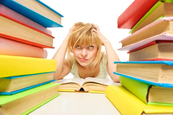 Cansada de los estudios, la joven está sentada en su escritorio con libros —  Fotos de Stock