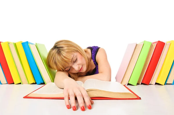 Cansada de estudos, a jovem mulher está dormindo em sua mesa com livros — Fotografia de Stock