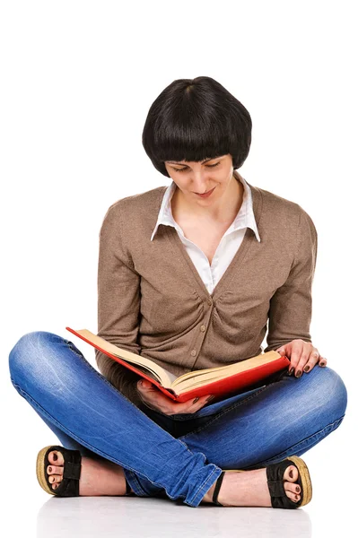Estudiante encantador sentado en un piso y leer el libro, aislado Fotos de stock libres de derechos