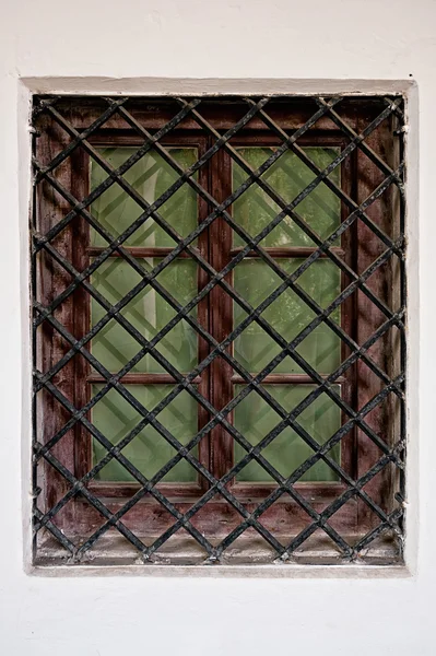 Fenster mit Eisengitter in Steinmauer schließen lizenzfreie Stockfotos