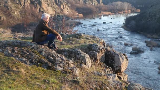 Ένας Ηλικιωμένος Άνδρας Κάθεται Και Θαυμάζει Την Ομορφιά Του Ποταμού — Αρχείο Βίντεο