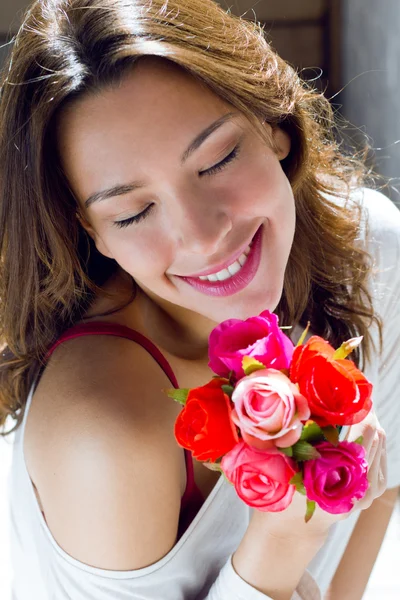 Jolie femme avec des fleurs à la maison — Photo