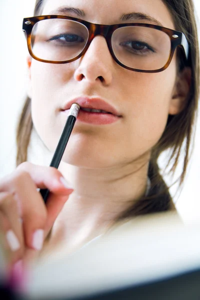 Young woman taking notes at home — Stock Photo, Image