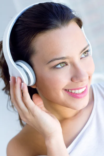 Bonita jovem mulher ouvindo música em casa — Fotografia de Stock