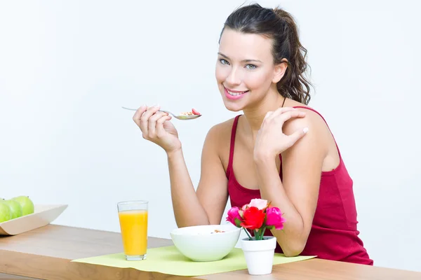 Ung kvinna äter frukost hemma — Stockfoto