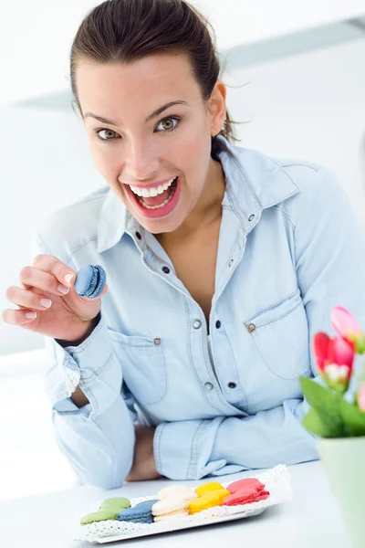 Mulher comendo biscoitos franceses em casa — Fotografia de Stock