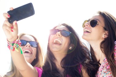 üç arkadaş bir smartphone ile fotoğraf çekmek