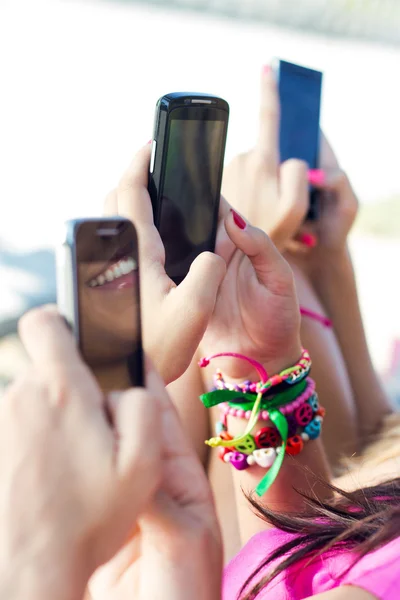 Três meninas conversando com seus smartphones — Fotografia de Stock