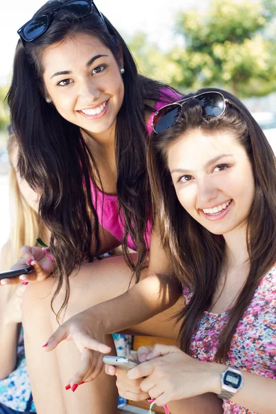 Three girls chatting with their smartphones — Stock Photo, Image