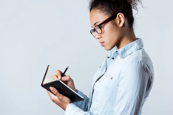 Jovem mulher negra tomando notas em casa — Fotografia de Stock