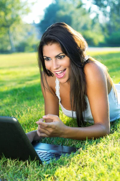 Retrato de mulher bonita em um parque com laptop — Fotografia de Stock