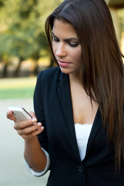 Schöne brünette Geschäftsfrau im Gespräch mit dem Smartphone in der pa — Stockfoto