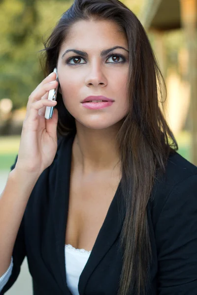 Hermosa mujer de negocios morena hablando por teléfono inteligente en el pa — Foto de Stock