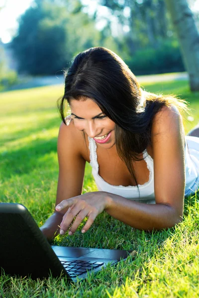 Portrait of beautiful woman in a park with laptop Royalty Free Stock Images