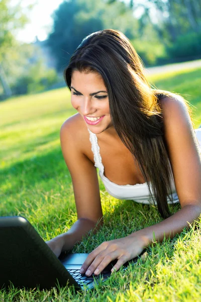 Portrait of beautiful woman in a park with laptop Stock Photo