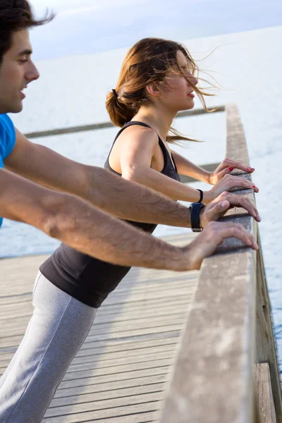 Par gör push ups nära havet — Stockfoto