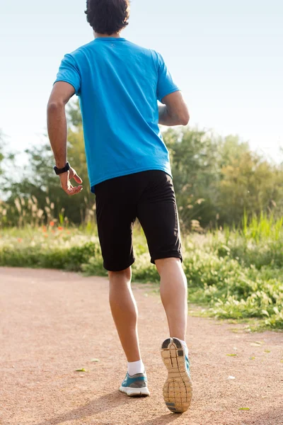 Мужчина в спортивной одежде бегает в парке — стоковое фото