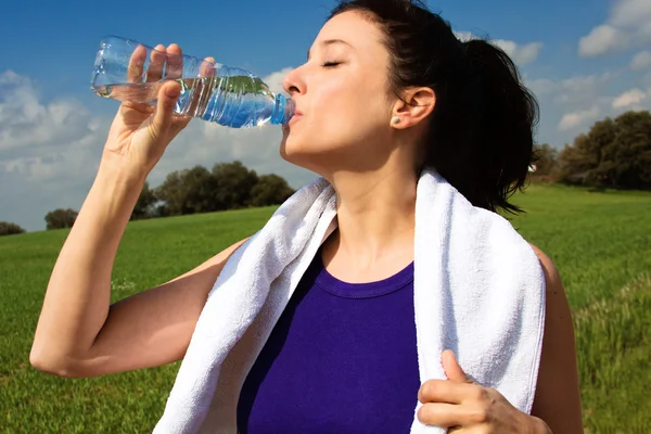 Ung kvinna dricksvatten efter sportaktiviteter — Stockfoto