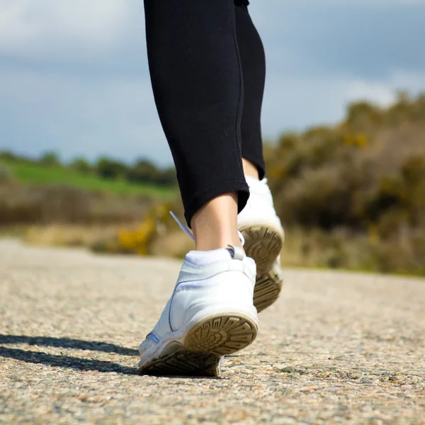 Frau in Sportkleidung läuft in einem Park — Stockfoto