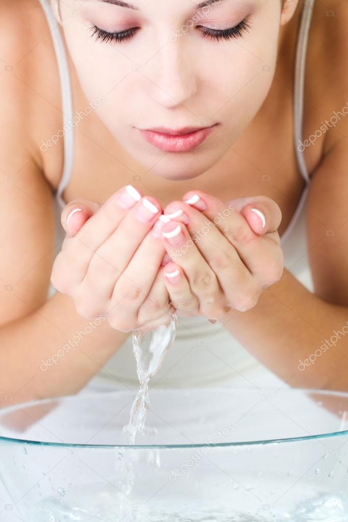 woman washing her face in the morning