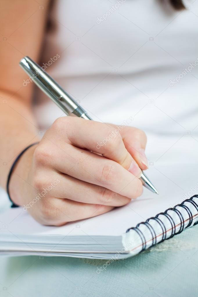 hand of young woman taking notes