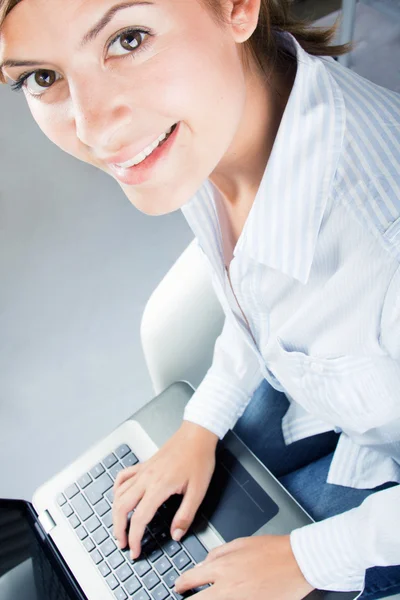 Bella donna d'affari che utilizza il computer portatile mentre guarda il camer — Foto Stock