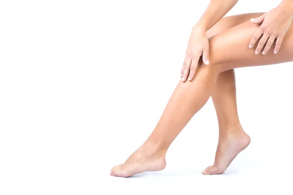 Уход за телом. Женщина наносит крем на ноги — стоковое фото