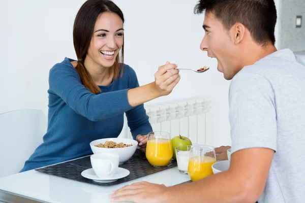 Jovem casal desfrutando de café da manhã na cozinha — Fotografia de Stock