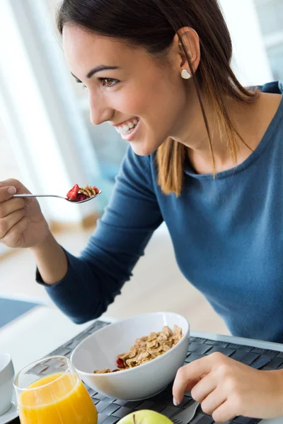 Ung kvinna njuter av frukost i köket — Stockfoto